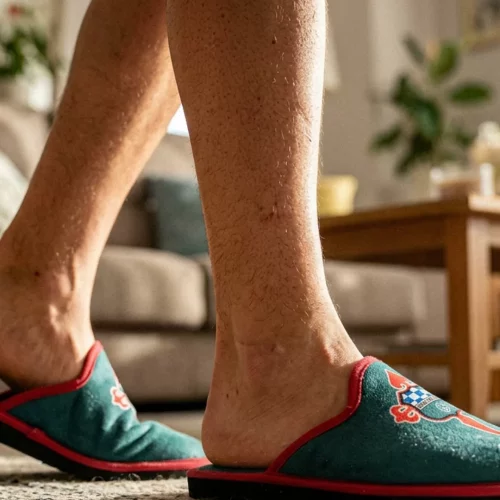 Zapatillas oficiales del Albacete Balompié blancas y negras sobre una superficie minimalista con elementos decorativos y fondo luminoso.